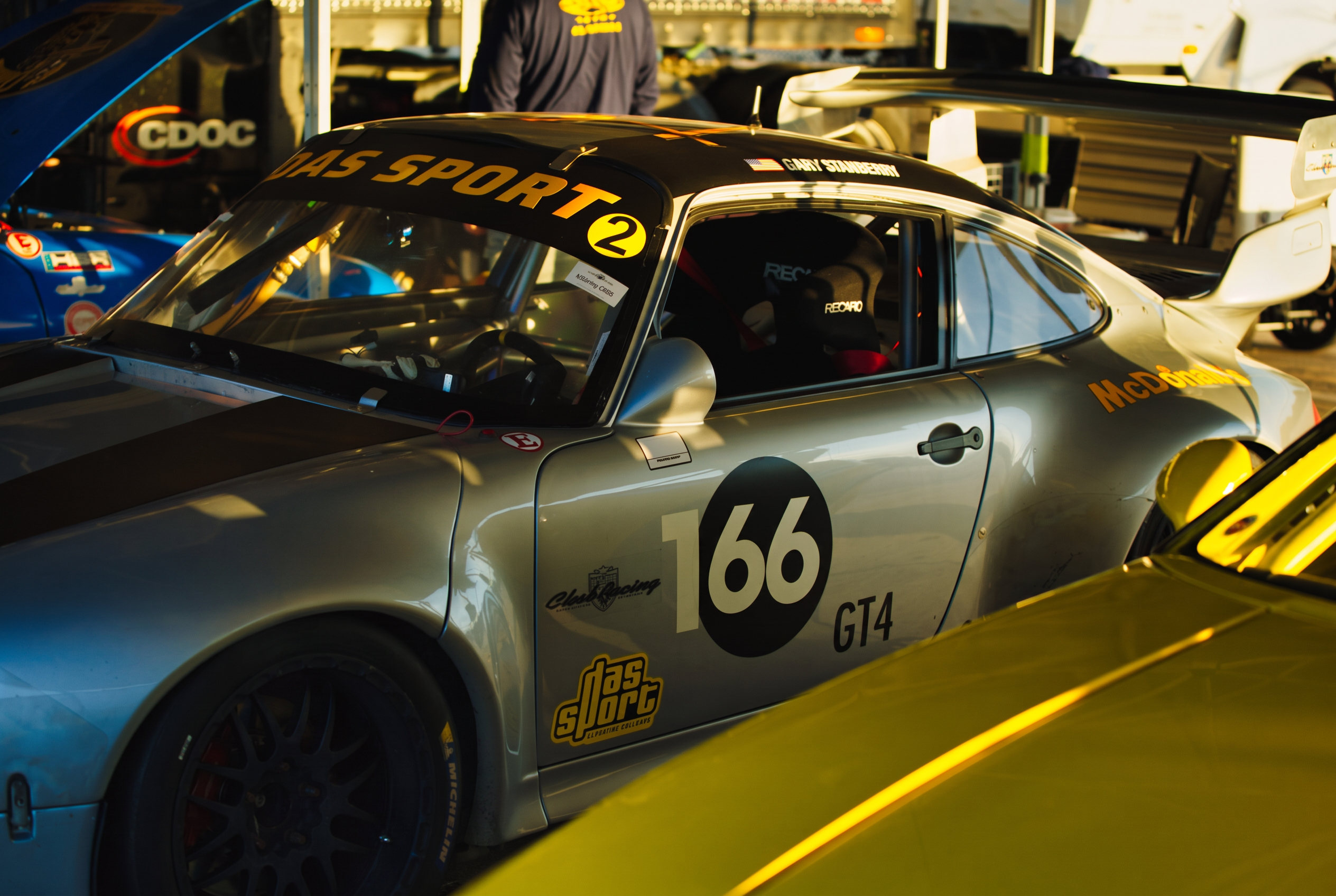 DAS Sport #166 GT4 Porsche 911 race car in the paddock