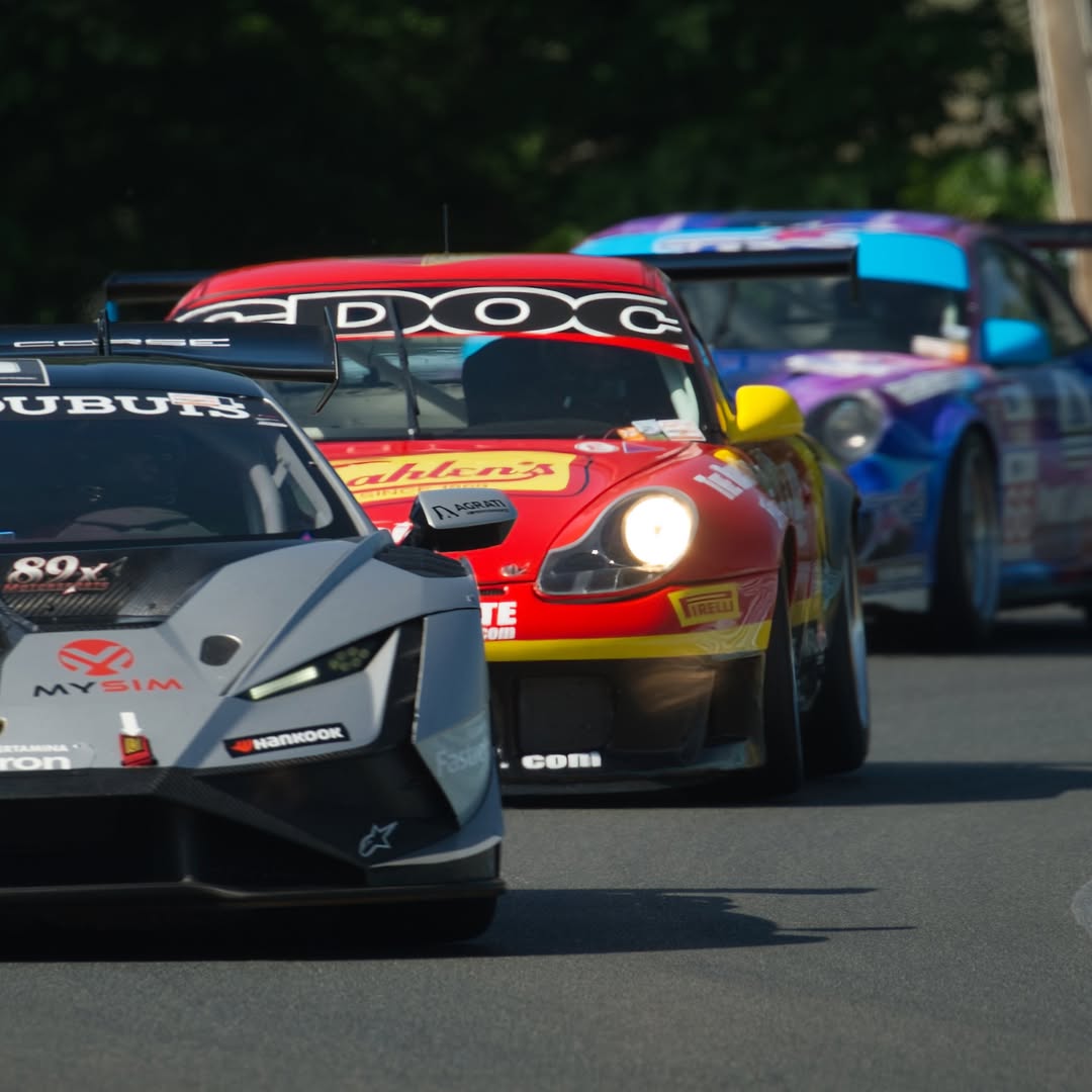 Race cars running nose-to-tail into a corner during a competition weekend